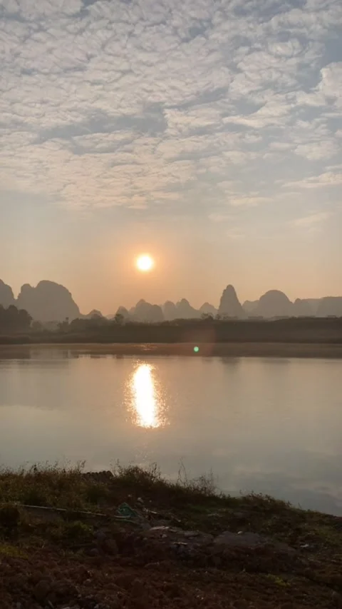 Vertical Time Lapse of Bamboo Raft Silhouette on Li River at Sunrise in Guil Video stock 326121258