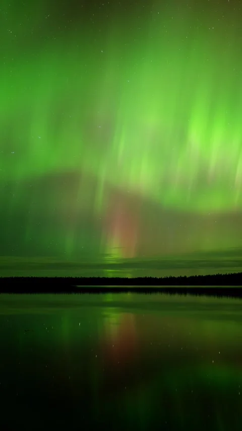 Vertical time lapse of bright colorful Aurora reflecting in a calm northern lake Stock Footage 295368997