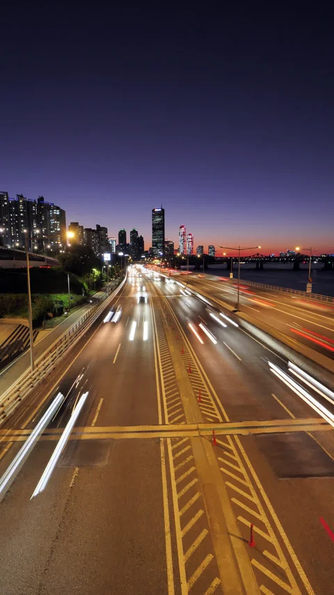 Vertical time-lapse of fast evening traffic on riverside highway in Seoul Video stock 295025075