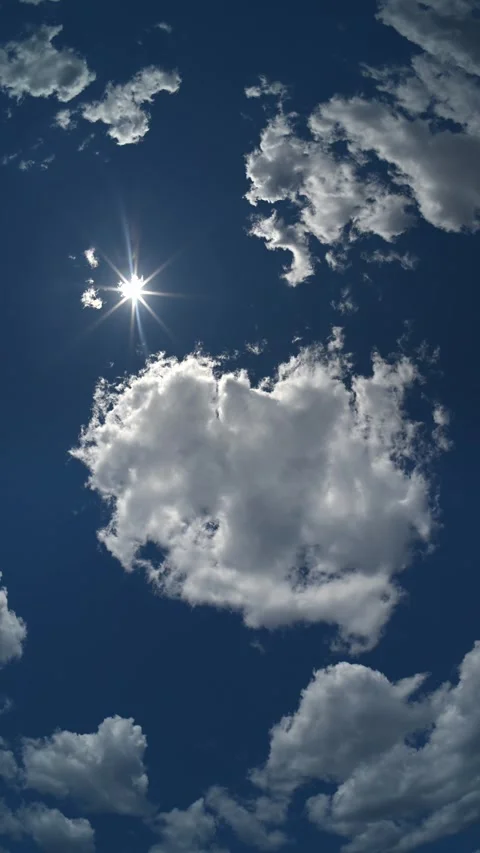 Vertical time lapse lookin straight up into a blue sky at the sun as clouds Stock Footage 337192951