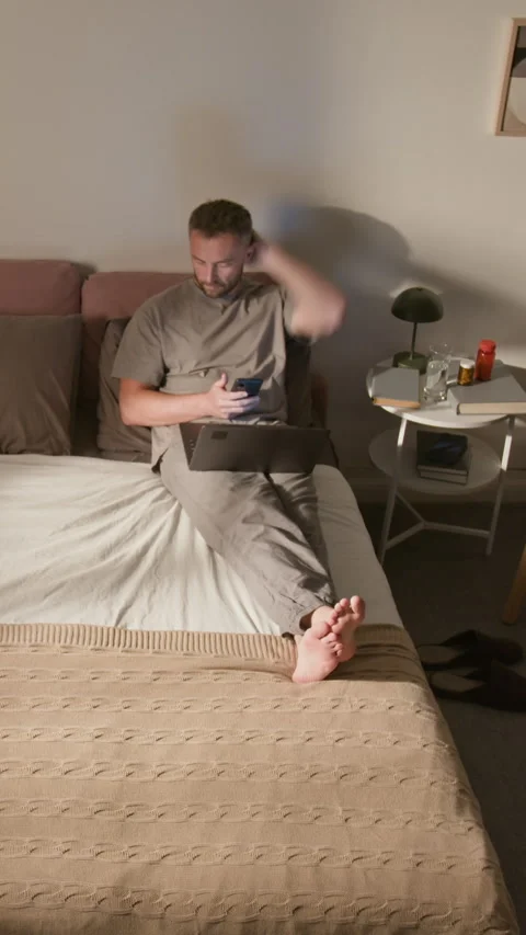 Vertical Time Lapse of Man Working on Laptop on Bed till Late Night Stock Footage 314840666