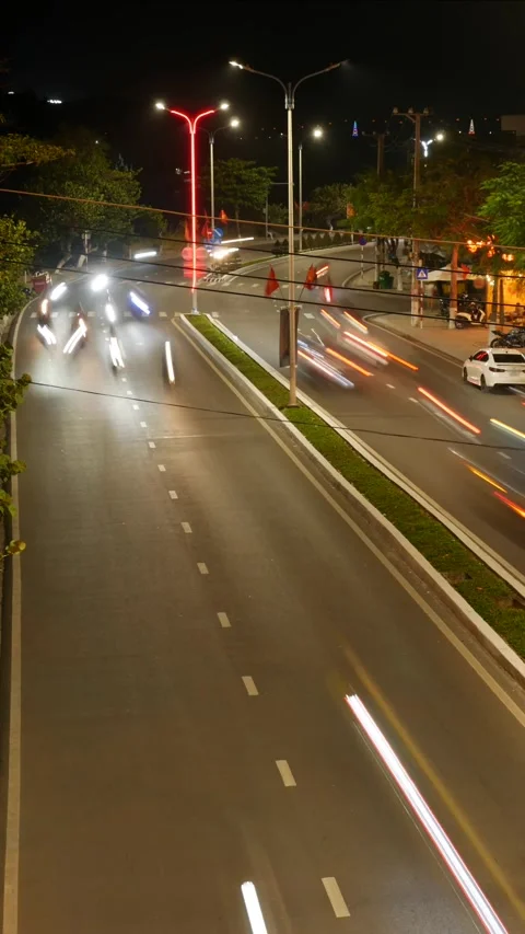 Vertical time lapse view of a night road where moving vehicles create long white 库存影片 330413140