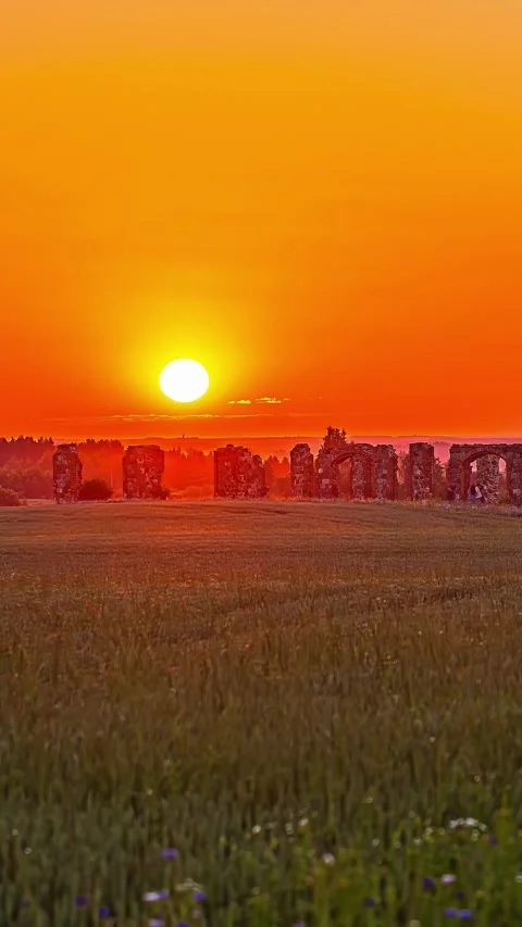 Vertical time lapse view of sun rising over ancient ruins on a grassy field. Stock Footage 317625943