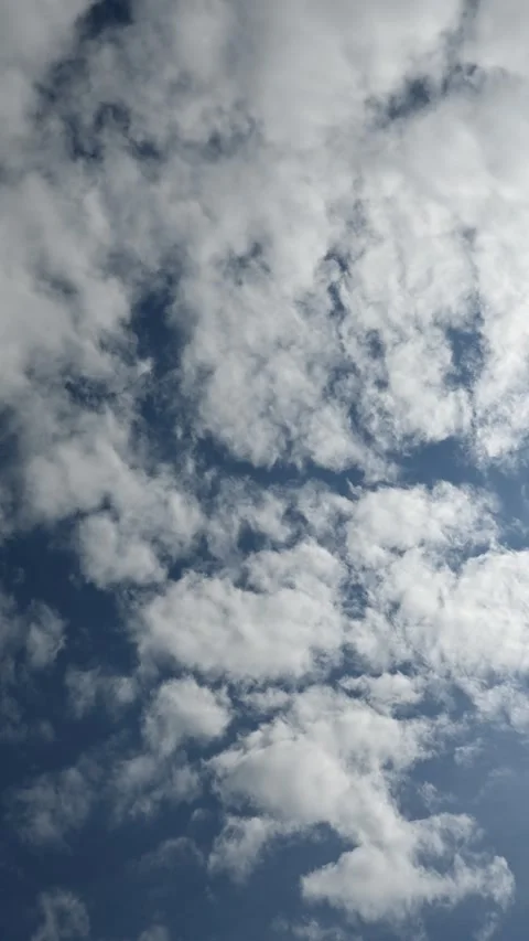 Vertical time lapse of white clouds moving through a blue sky slowly clearing to Stock Footage 326496024