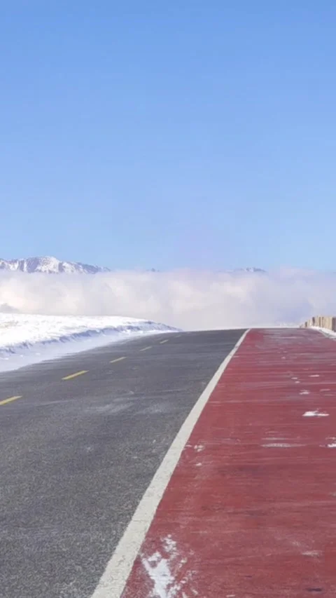 Vertical timelapse of car driving on mountain road above sea of clouds in wi Stock Footage 327585709