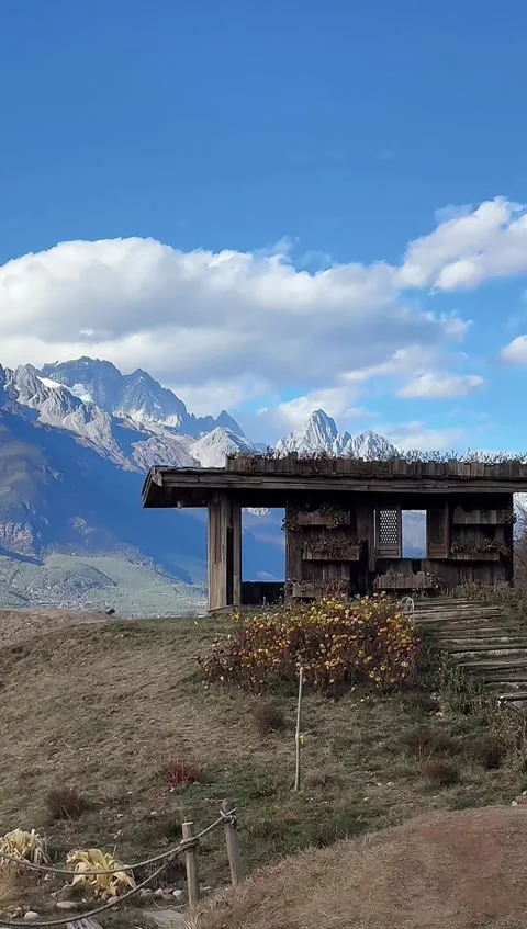 Vertical Timelapse of Clouds Moving Over Wooden Cabin and Jade Dragon Snow M Stock Footage 326079603