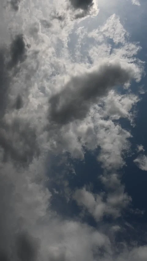 Vertical timelapse of gray clouds moving across the sky with the sun at the top Stock Footage 311285423