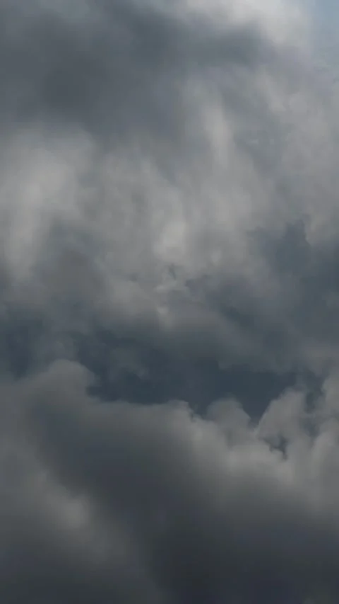 Vertical timelapse of gray rain clouds churning and drifting through a stormy Stock Footage 311285345