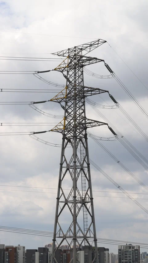 Vertical time‑lapse of high‑voltage electricity pylon against blue cloudy sky Stock Footage 345013184