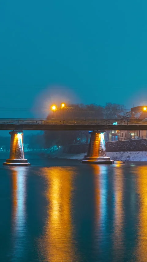 Vertical timelapse of an illuminated pedestrian bridge on a snowy winter river Stock Footage 277401965