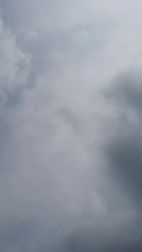 Vertical timelapse looking up at stormy churning clouds moving through a gray sk Stock Footage 311737970