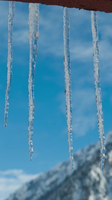 Vertical timelapse of melting icicles with alpine background Video stock 327826957