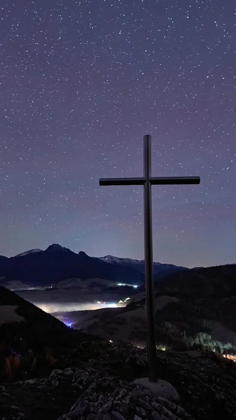 Vertical timelapse of a metal cross on a mountain top under a starry night sky Stock Footage 336394833