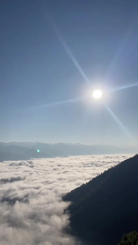 Vertical timelapse of rolling sea of clouds over mountains with bright sunbu Stock Footage 327690577