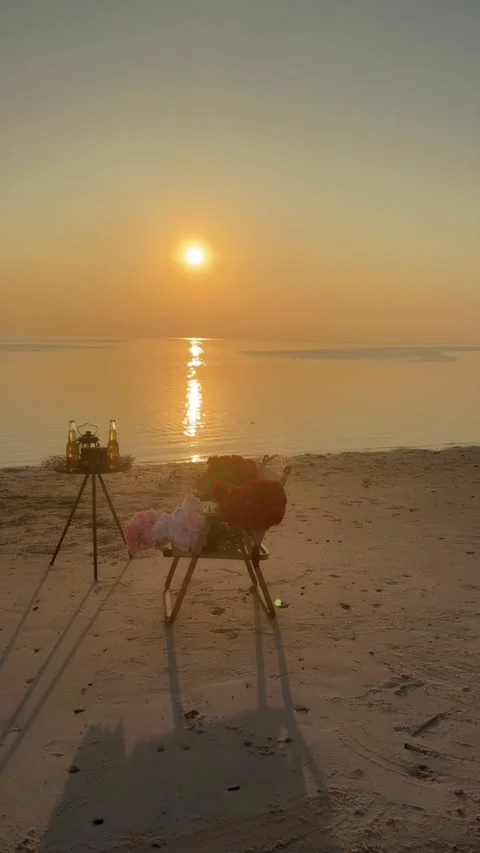 Vertical Timelapse Romantic Beach Sunset Date Setup with Flowers and Beer Bo Stock Footage 326979276