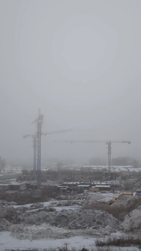 Vertical Timelapse of Snowy Construction Site with Tower Cranes in Winter Fog 스톡 동영상 297264981