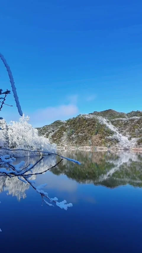 Vertical timelapse of snowy mountain reflection rippling in blue lake water Stock Footage 327583714