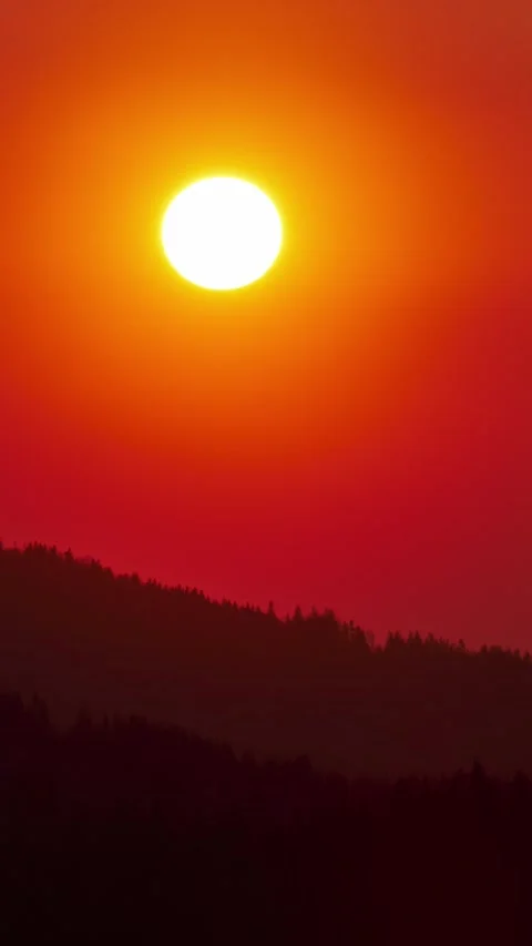 Vertical timelapse of vibrant red sunset over dark mountain forest for social Stock Footage 327521616