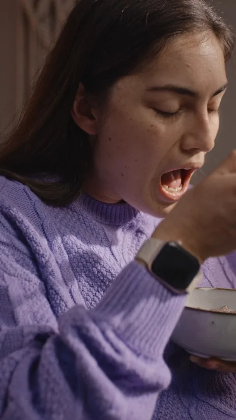 Vertical of Tired Woman Putting down Smartphone and Eating Breakfast Video stock 344105391