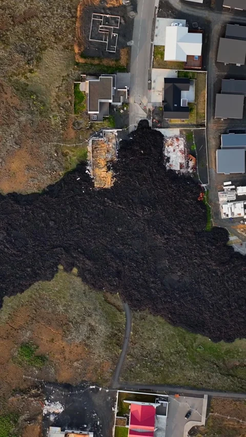 Vertical top-down aerial over Grindavik, Iceland, where a broad black lava Vídeo Stock 345994855