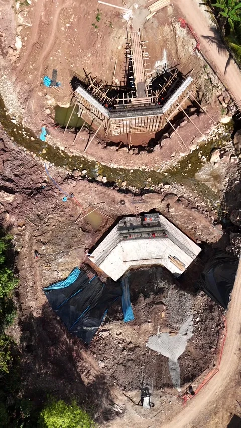 Vertical top-down aerial view of a bridge construction site Stockbeeldmateriaal 333481138