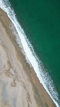 Vertical Top Down Aerial View of Emerald Sea and Sandy Beach Foto stock