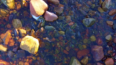 Vertical Top Down Drone Shot of Stones Under Clear Loch Flowing Water Stock Footage 229765385