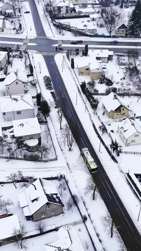 Vertical top-down drone shot of a snowy suburban intersection with zebra 動画素材 328356572