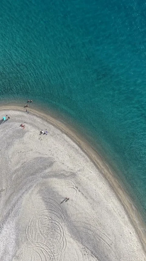 Vertical top down drone shot of Possidi sandbar beach with turquoise sea water i Stock Footage 341460399