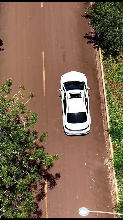 Vertical Top Down Drone Tracking White Car Toward Stop Sign Vídeo Stock 346853560
