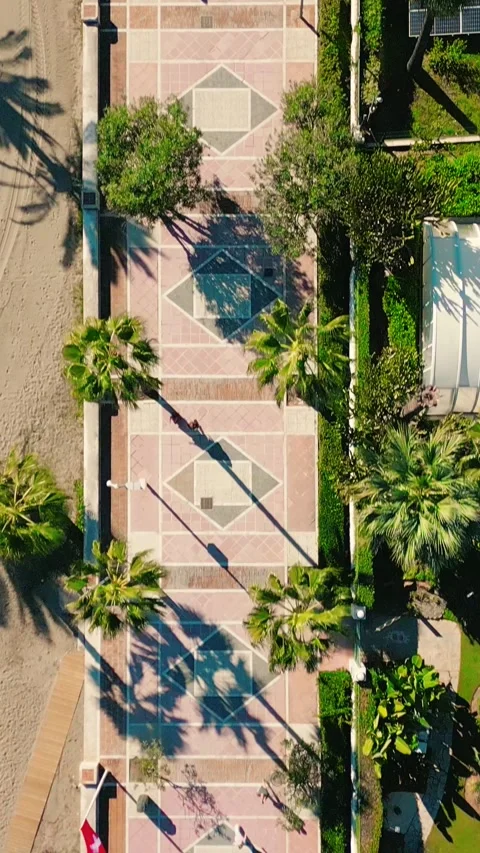 Vertical top-down drone view of people walking along Puerto Banús promenade Stock Footage 328600603