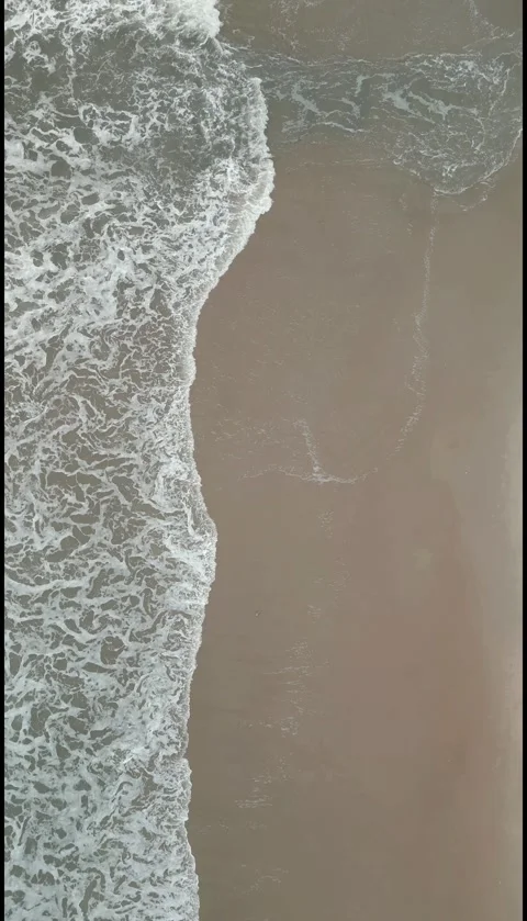 Vertical Top Down Drone View of Ocean Waves Rolling onto Sandy Beach. Stock Footage 330361449