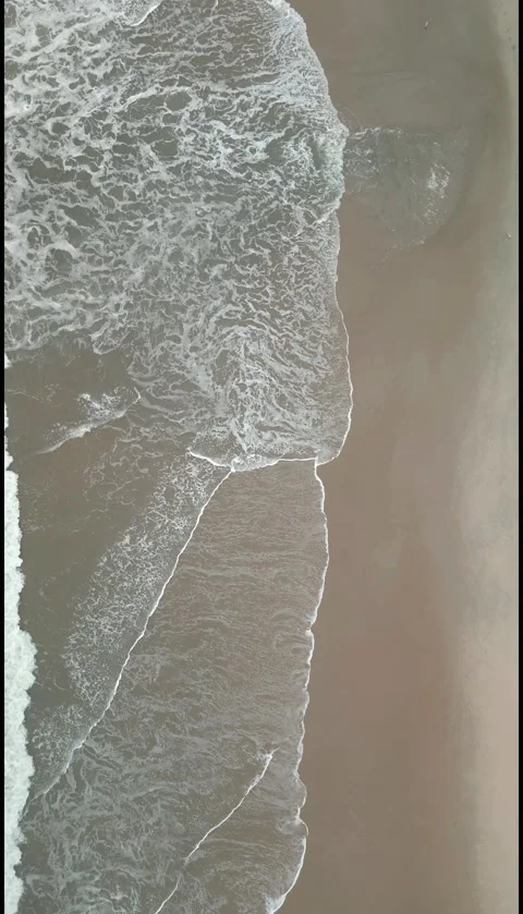 Vertical Top Down Drone View of Ocean Waves Rolling onto Sandy Beach. Stock Footage 330361455