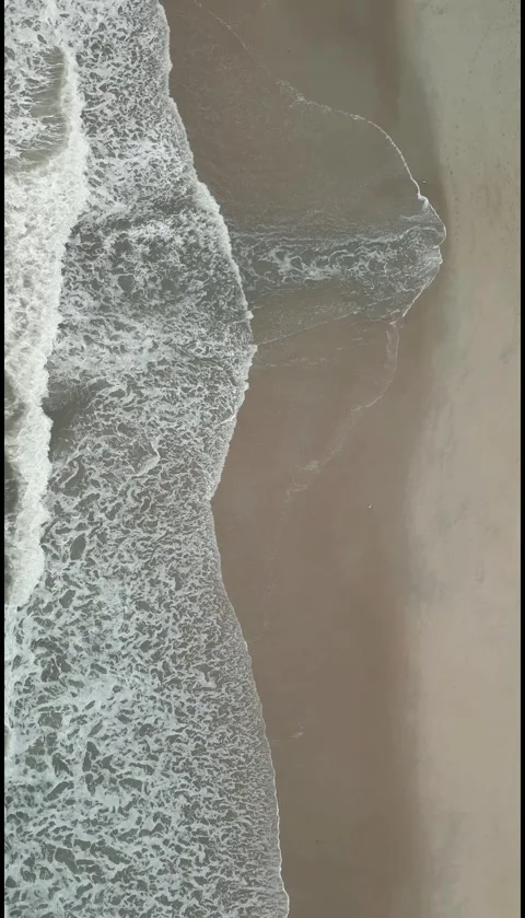 Vertical Top Down Drone View of Ocean Waves Rolling onto Sandy Beach Stock Footage 330361459