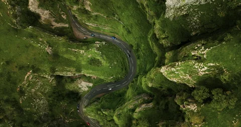 Vertical top-down view on cars driving between saturated green cliffs of Cheddar Stock Footage 288758191