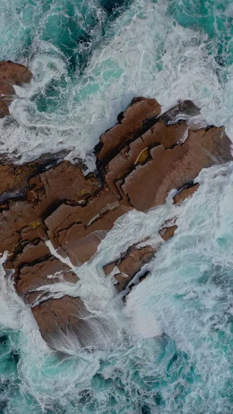 Vertical top-down view powerful ocean waves crashing rocky reef Stock Footage 339781814