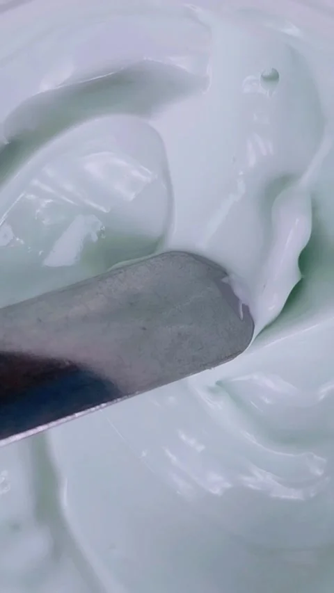 Vertical top down view of stirring cream slowly with a spoon in top to bott.. Stock Footage 339405335