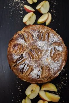 Vertical top view of an apple pie with powdered sugar on a black background Stock Photos