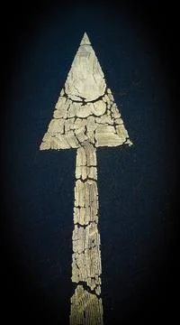 Vertical top view of an old road sign on the asphalt showing the direction Stock Photos