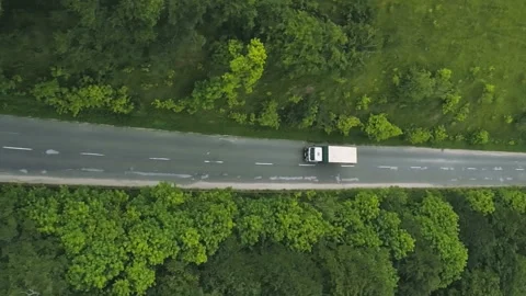 Vertical topdown view of truck trailer driving down a winding road through the Stock Footage 231324931