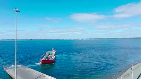 Vertical tracking overall view of boat leaving coast Stock Footage 340992047