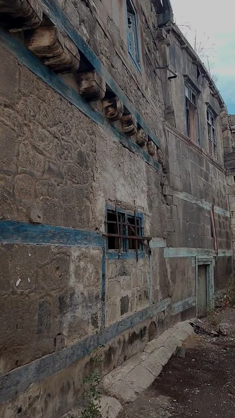 Vertical tracking shot of a historical stone mansion facade with faded blue Stock-Footage 328402304