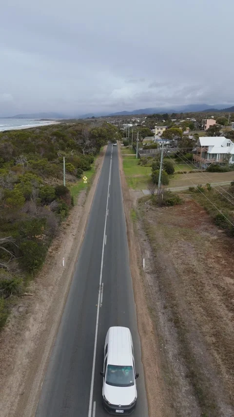 Vertical tracking of vehicles on a scenic coastal road, East Coast Tasmania. Vídeo Stock 332542565