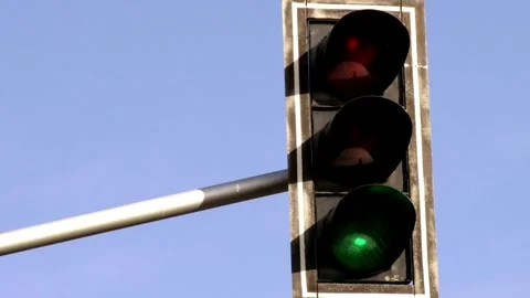 Vertical traffic light against a backdrop of blue sky and skyscrapers, Stock Footage 256738164