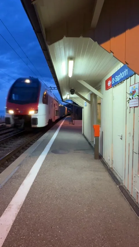 Vertical train passing St-Saphorin station at dusk Switzerland Stockbeeldmateriaal 333085575