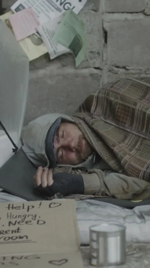 Vertical of Troubled Young Man Sleeping on Ground Bundled in Plaid Blanket Stock Footage 315315287