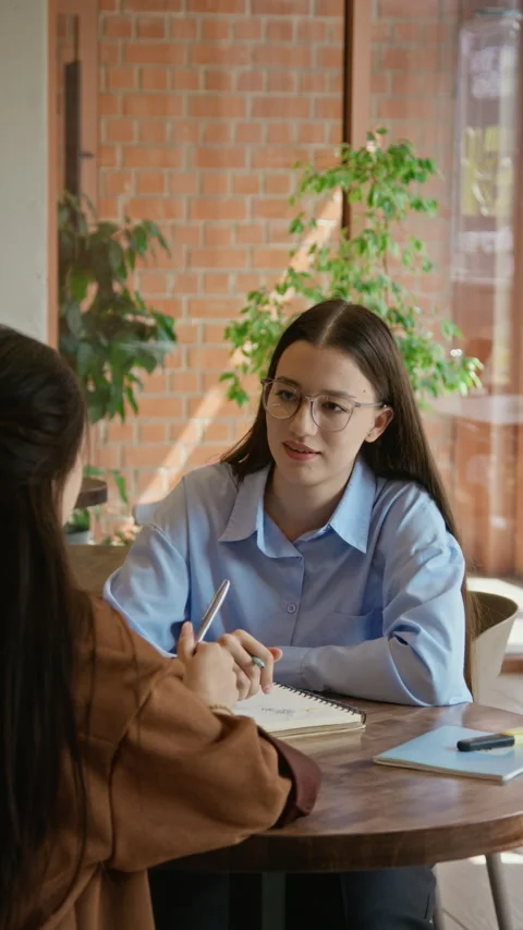 Vertical of Two Diverse Female Students Brainstorming Creative Ideas in Cafe Stock Footage 342126209