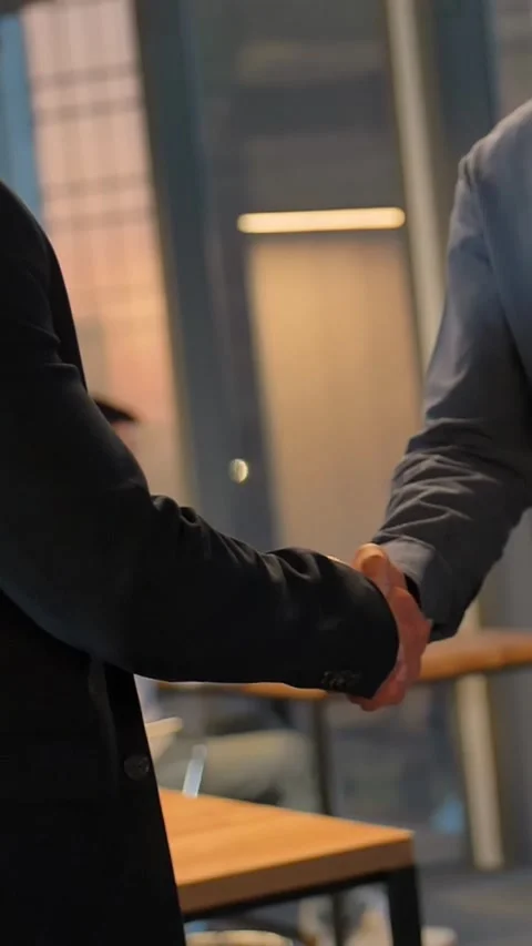 Vertical of Two entrepreneur shaking hands inside of modern business office with Stock Footage 277279435