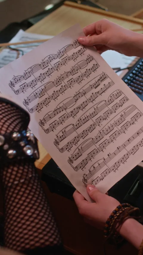 Vertical of Two Girls Studying Sheet Music during Creative Collaboration Stock Footage 342813564