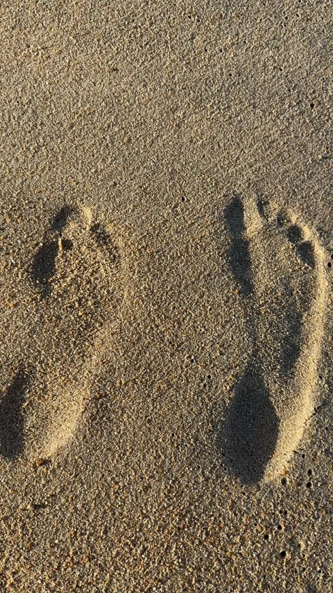 Vertical Two Human Footprints on Sandy Beach with Ocean Background Stock Footage 330702737